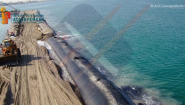 Construction d'un brise-lames en forme de L contenant du sable, Émirats arabes unis